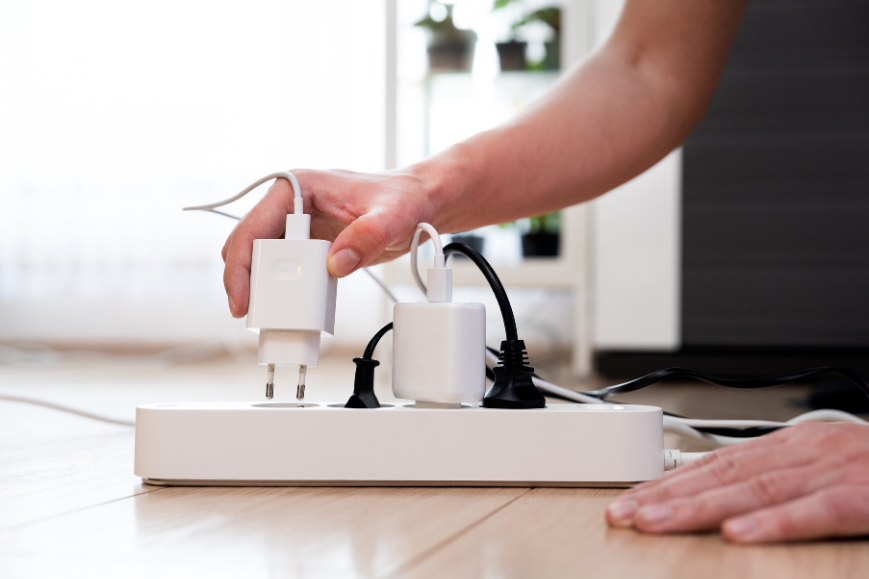 Hand pluging a phone charger at an extension