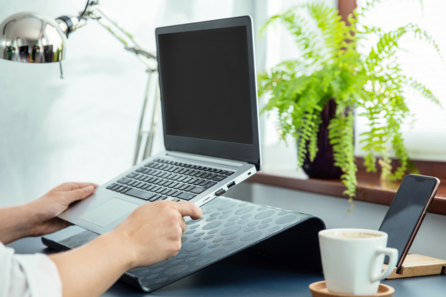 Woman putting her laptop on a laptop ergonomic riser