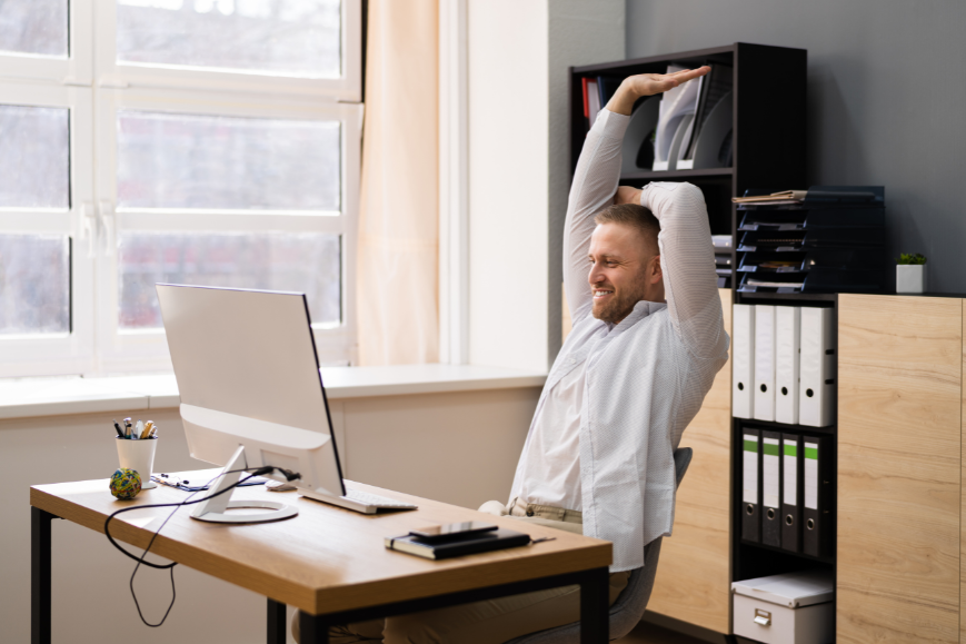 Man in front of his computer doing some stretching while sitting