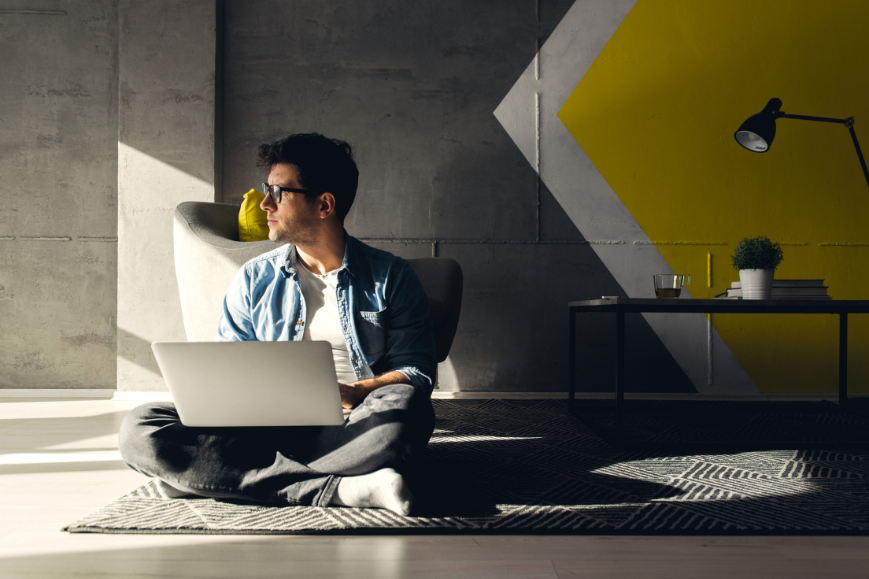 A freelancer sitting on the flor with his laptop