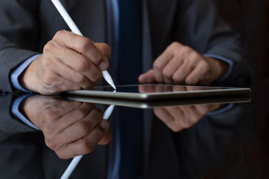 Business man in suit hand using digitized pen sign contract on digital tablet. Electronic signature concept.