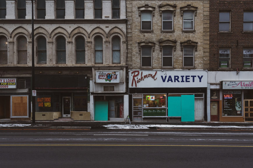 Urban street with a mix of open and close stores, showcasing the changing retail landscape.